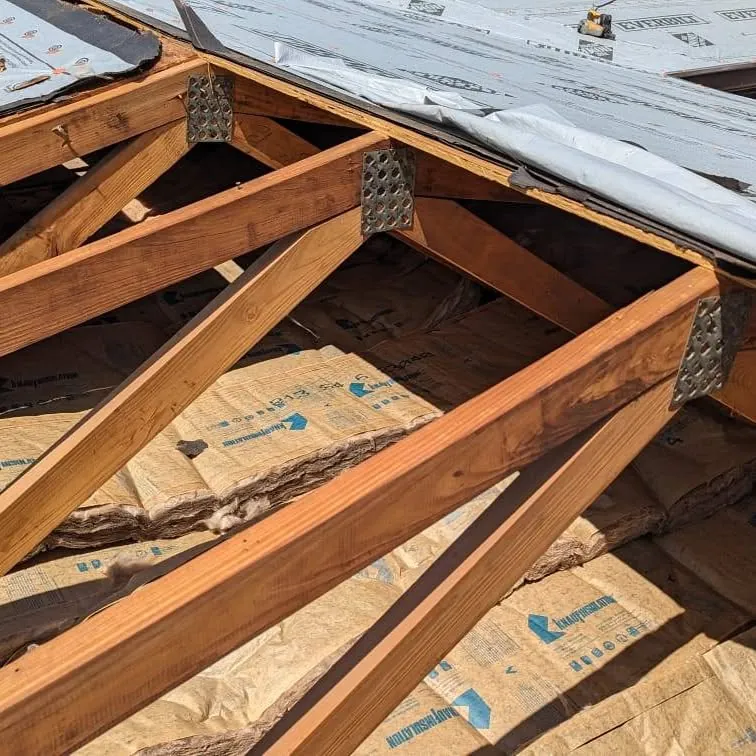 Wood roof trusses and decking seen from inside the attic