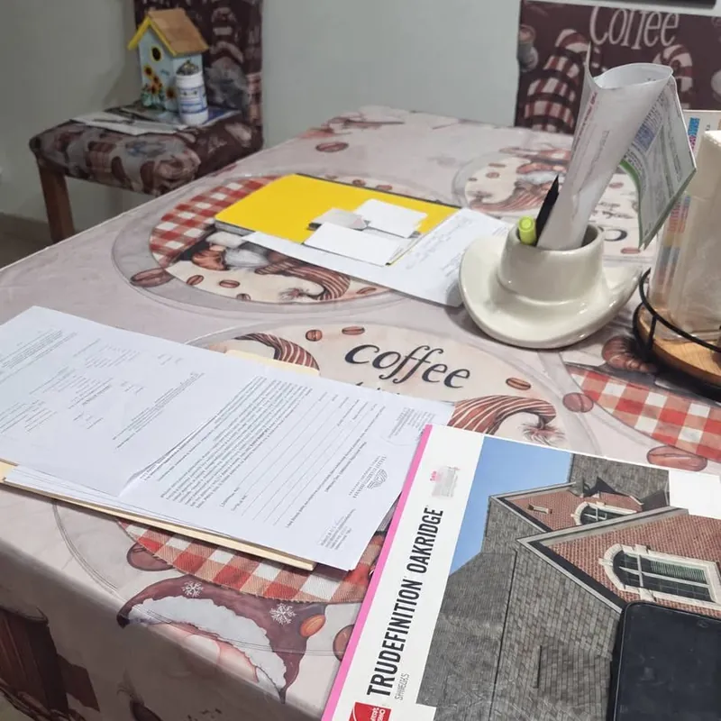 Roofing contract paperwork and an Owens Corning shingle brochure on a kitchen table