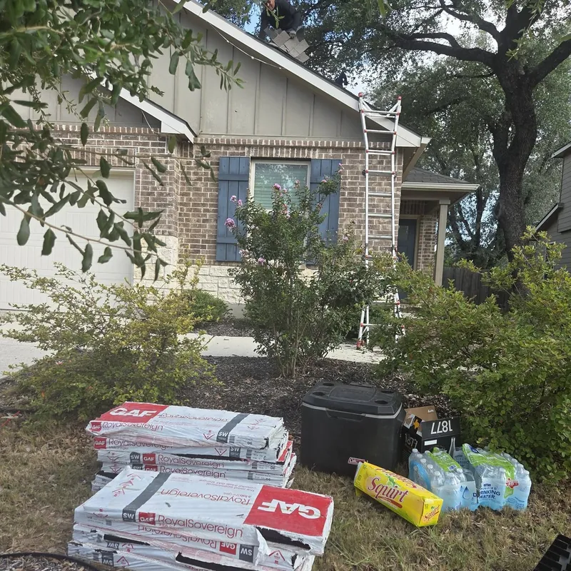 Shingle bundles and roofing supplies delivered to a front yard before a roof job