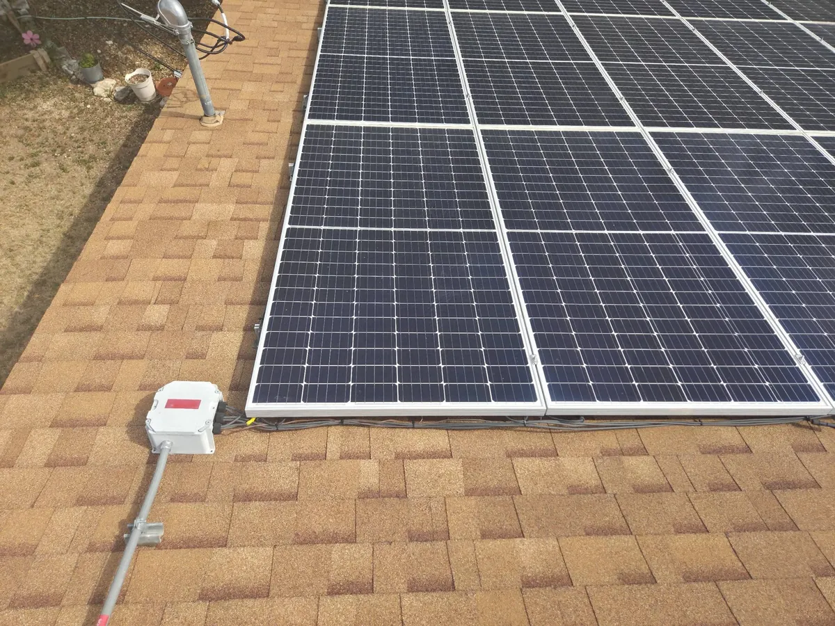 Solar panels mounted on a new tan shingle roof